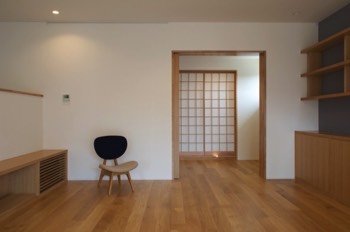 Living area with TV shoves on the left, bookshelves on the right and piano room and the Japanese room sliding doors closed.   Living area with TV shoves on the left, bookshelves on the right and piano room and the Japanese room sliding doors closed.